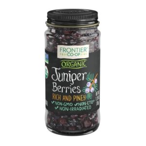 Whole organic juniper berries in a glass bottle, showcasing the high-quality, non-irradiated product from Frontier Co-op.
