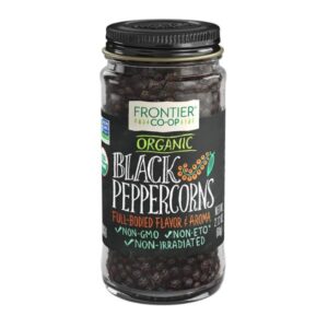 Organic whole black peppercorns in a glass jar, showcasing premium quality and size.